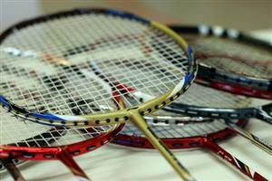 Several badminton rackets stacked together 
